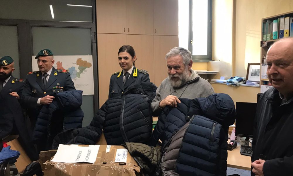 Abiti contraffatti sequestrati dalle fiamme gialle donati alla Caritas di Como