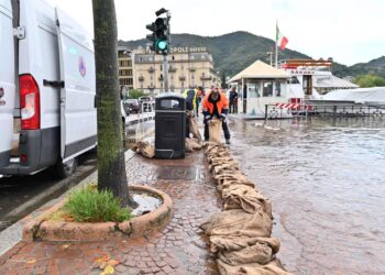 Posizionamento sacchi per contenere il lago di Como in piazza Cavour