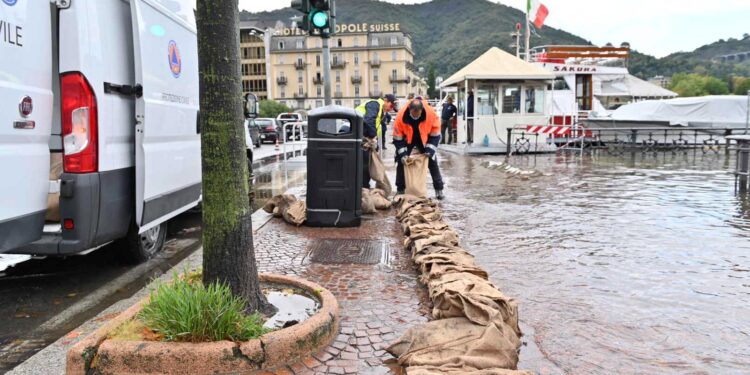 Posizionamento sacchi per contenere il lago di Como in piazza Cavour