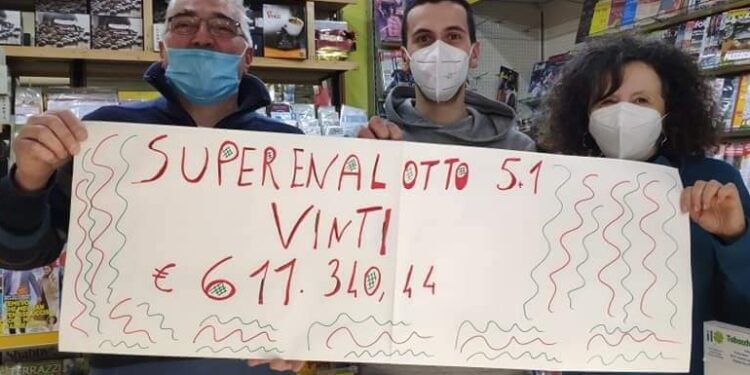 I gestori dell'edicola di Binago mostrano il cartello vincita superenalotto