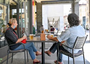 como due persone seduto al tavolo di un bar