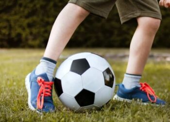 Palla da calcio tra i piedi di un bambino