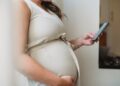 donna in gravidanza con in mano un callulare