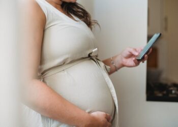 donna in gravidanza con in mano un callulare