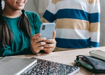 uso responsabile delle tecnologie. nella foto due bambini con il cellulare