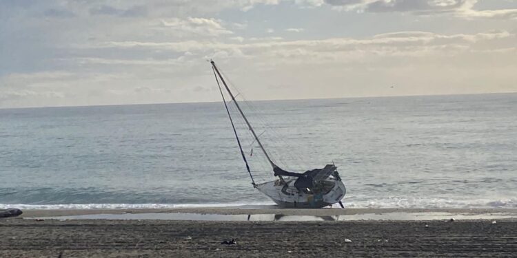 Barca a vela arenata su spiaggia nella Locride