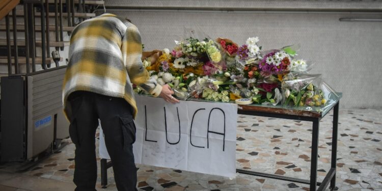 Sotto un cartellone con la scritta 'Luca riposa in pace'