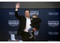Il patron della Tesla sul palco di Atreju con uno dei figli
