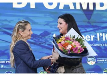 Arianna Meloni le consegna dei fiori dal palco di Caivano