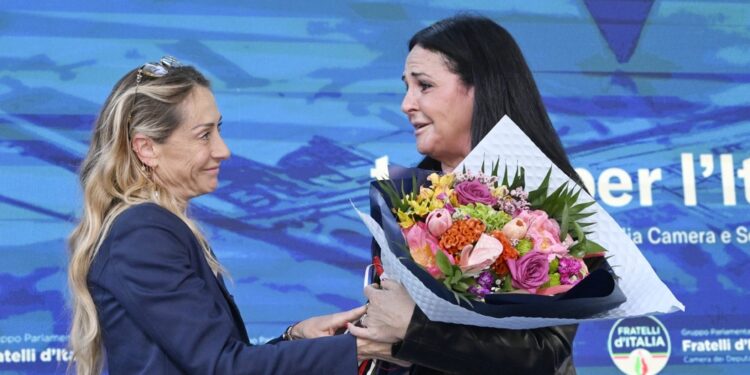 Arianna Meloni le consegna dei fiori dal palco di Caivano