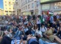 Manifestanti distesi a terra mentre si diffonde rumore bombe