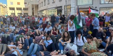 Manifestanti distesi a terra mentre si diffonde rumore bombe