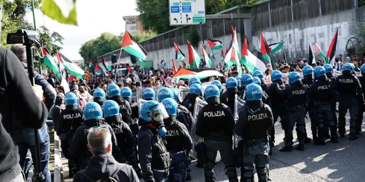 I manifestanti di fronte agli agenti che sbarrano il percorso