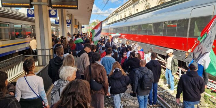 Manifestanti con bandiere Palestina lanciano slogan