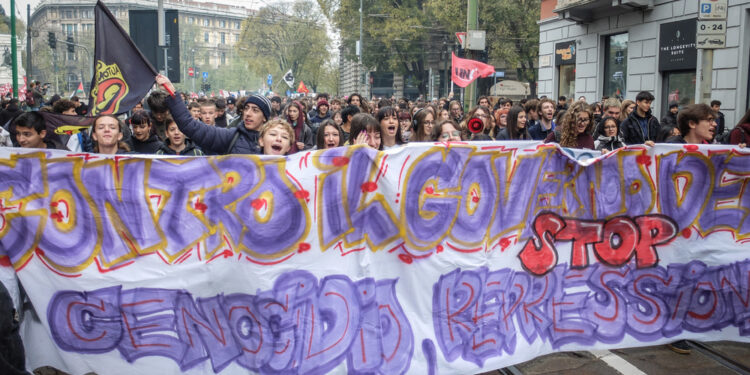Cartelli con volto Schlein e Meloni con impronte rosso sangue