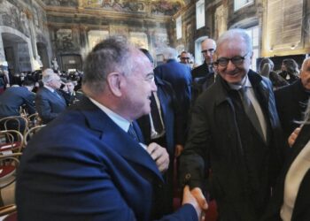 Stretta di mano e sorrisi con il sottosegretario Mantovano