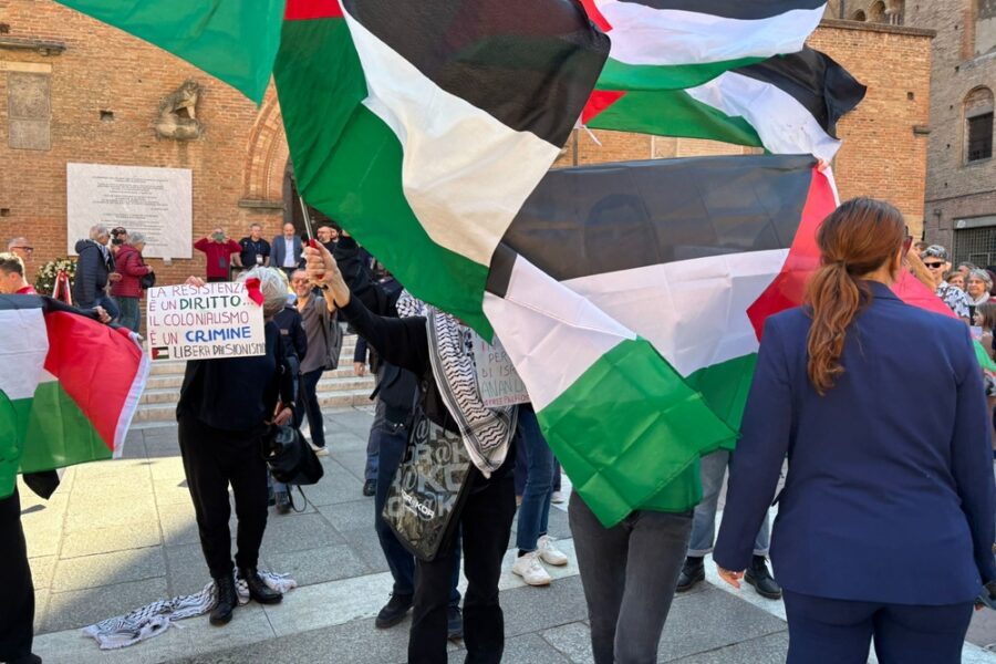 Un gruppo in piazza con bandiere della Palestina e cartelli