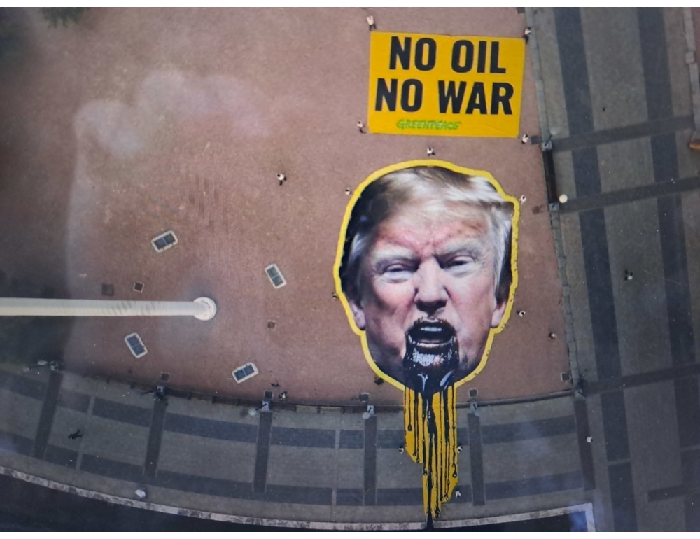 Greenpeace esibisce immagine di Trump che vomita petrolio, ‘no oil, no war’
