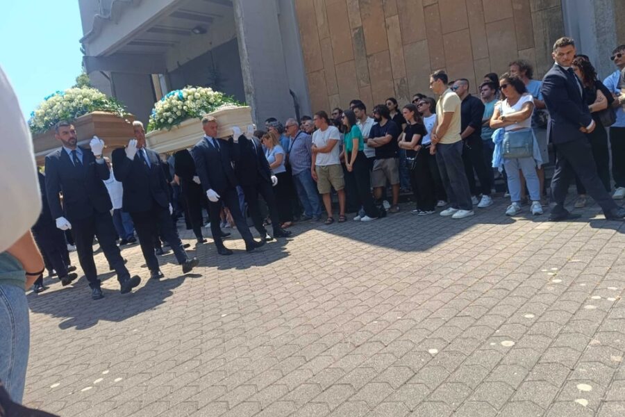 Feretri portati fuori dalla chiesa tra le ali della folla in silenzio