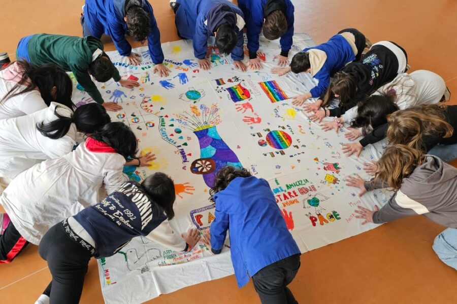 Oltre 200 bimbi decorano lenzuola bianche riciclate. Opera d'arte collettiva da 165 metri