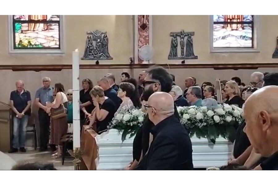 Celebra il vescovo di San Severo. Fasci di rose bianche adornano il feretro