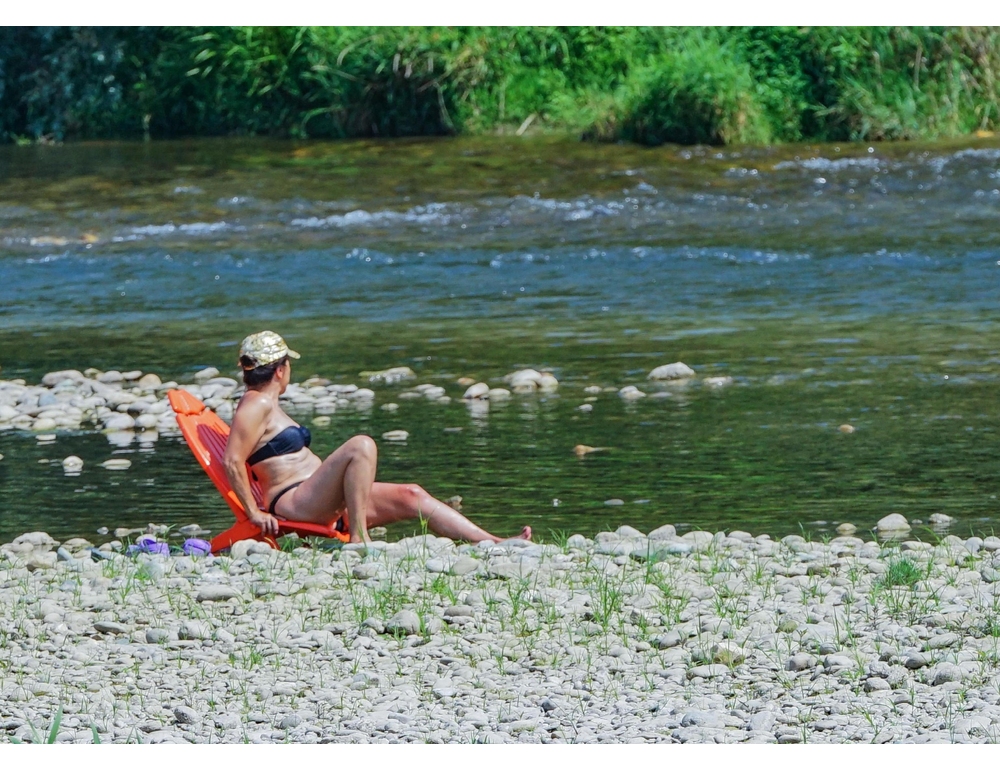 Prende il sole in topless sul fiume, multata ‘perché si vedeva dal ponte’