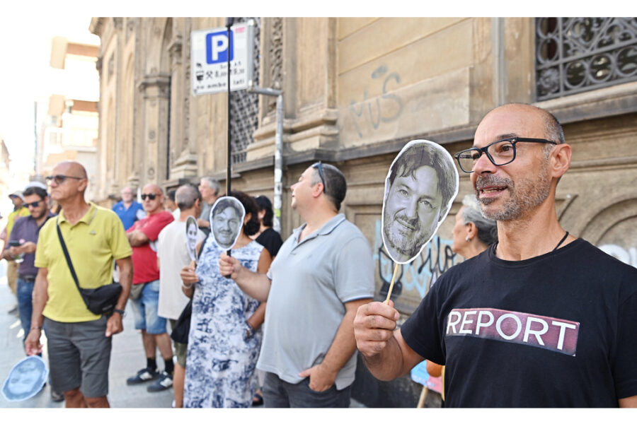 Manifestanti in strada con i cartonati dei volti più noti del programma